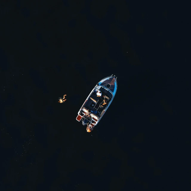a small boat floating on top of a body of water, by Sebastian Spreng, pexels contest winner, dark blue water, 2 people, view from the sky, black