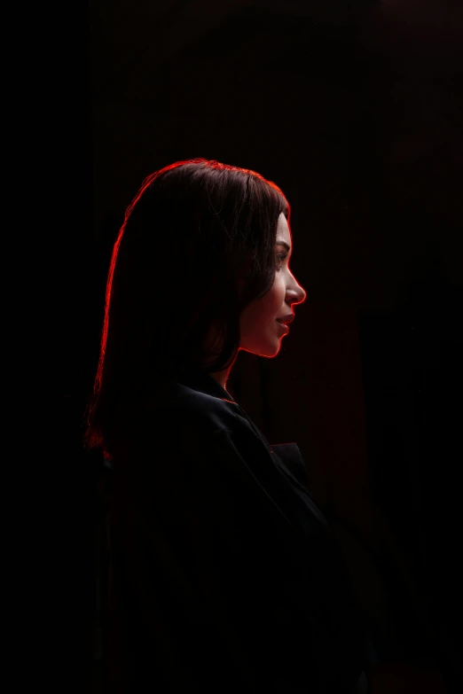 a woman standing in front of a red light, inspired by Elsa Bleda, digital art, side profile portrait, dark. no text, kiko mizuhara, dark. studio lighting