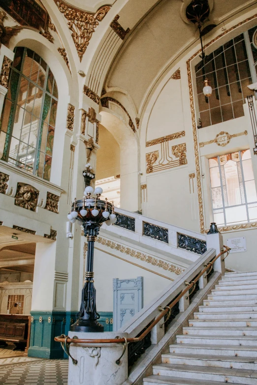 a staircase leading to the second floor of a building, inspired by Sydney Prior Hall, pexels contest winner, art nouveau, 2 5 6 x 2 5 6 pixels, ornate with gold trimmings, train station, set inside of the bank