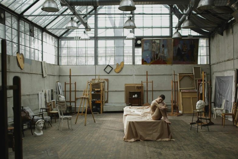 a woman sitting on top of a bed in a room, a hyperrealistic painting, trending on unsplash, visual art, in a warehouse, morandi, in a factory, still from film