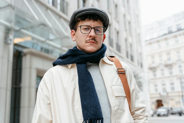 a man wearing a hat, scarf and glasses, by Nina Hamnett, trending on pexels, post graduate, thin moustache, in london, navy