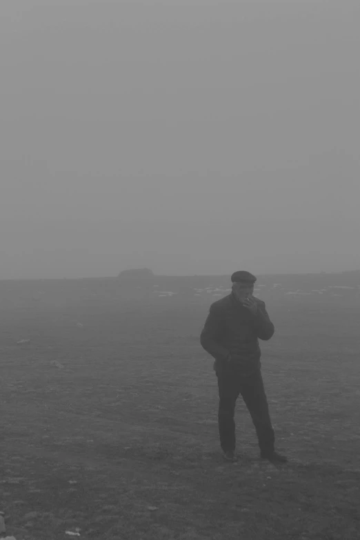 a man standing in a field on a foggy day, a black and white photo, foreboding sea, obscured face, standing on a martian landscape, photograph taken in 2 0 2 0