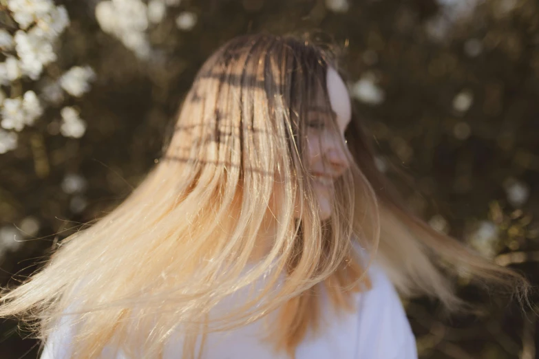 a woman with long blonde hair standing in front of trees, pexels contest winner, happening, hair fanned around, close - up on face, extremely pale, smiling down from above