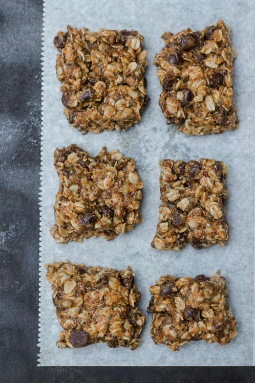 a tray of granola bars sitting on top of a table, a portrait, by Nina Hamnett, unsplash, square shapes, chocolate. rugged, on a gray background, victoria