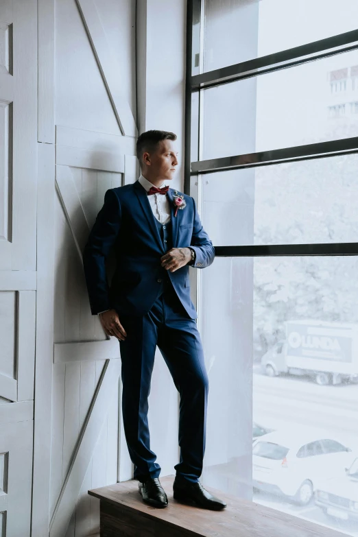 a man in a suit standing next to a window, liam brazier, wedding, looking content, rectangle