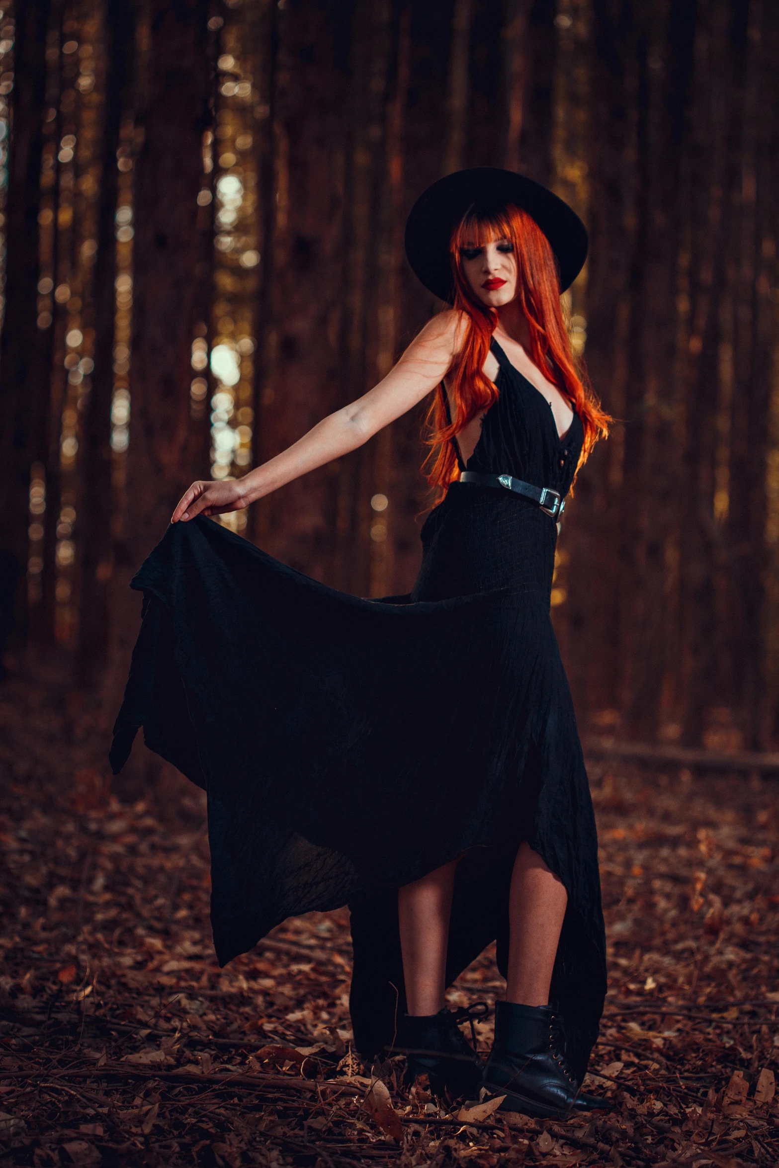 a woman in a black dress is standing in the woods, pexels contest winner, long orange hair, beautiful cowboy witch, profile image, astral witch clothes