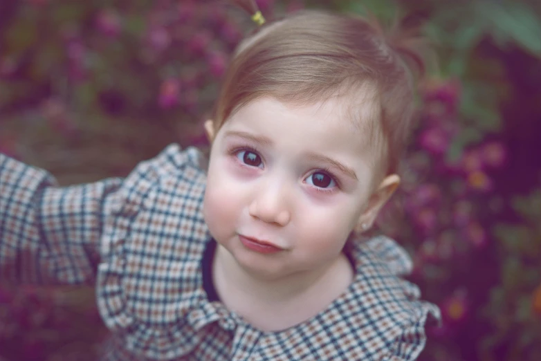 a little girl holding a flower in her hand, pexels contest winner, realism, concerned expression, short brown hair and large eyes, 2 years old, ((portrait))