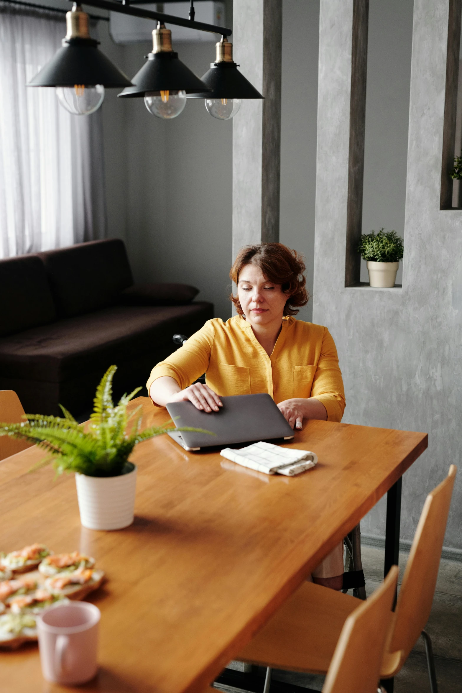 a woman sitting at a table with a laptop, on a table