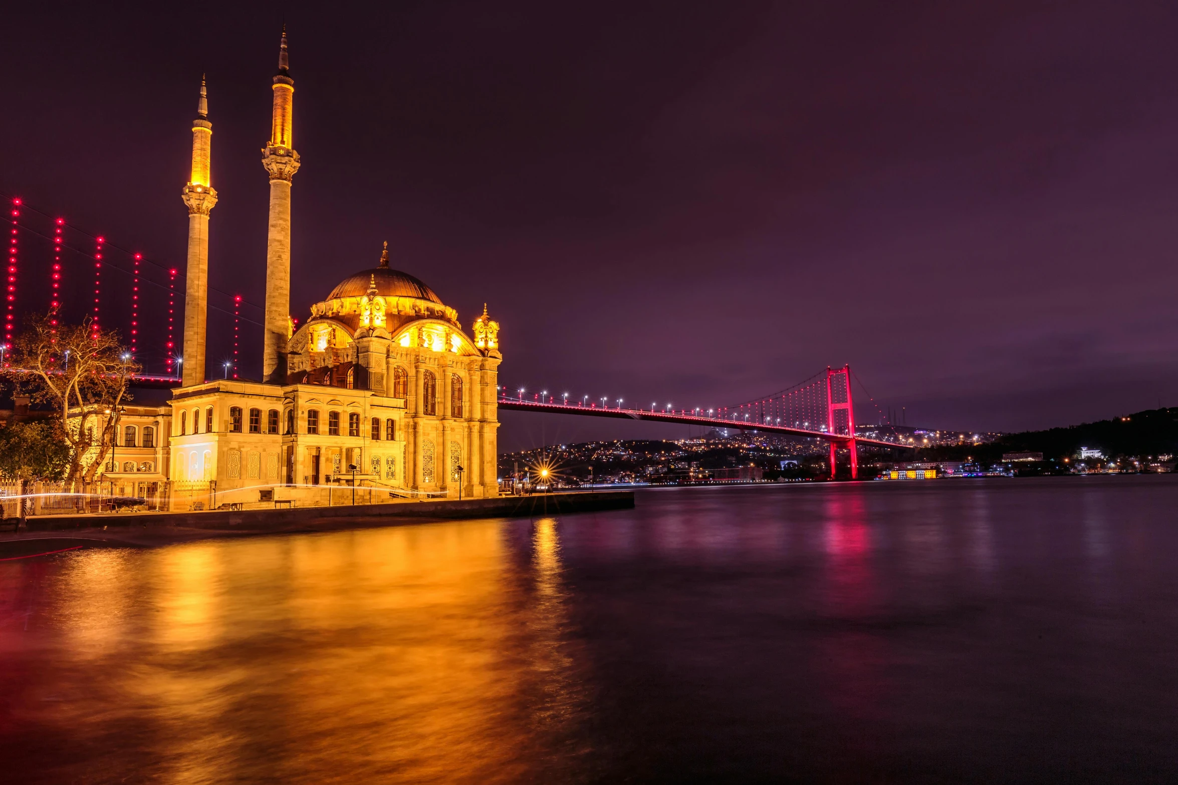 a large building sitting on top of a river next to a bridge, inspired by Osman Hamdi Bey, pexels contest winner, hurufiyya, square, nightlife, mosque, view from the sea