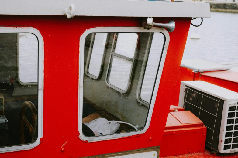 a red boat sitting on top of a body of water, by Julia Pishtar, looking in the window, closed visor, interior shot, on a canva