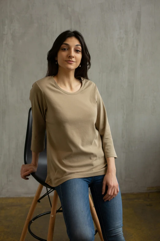 a woman sitting on a chair in a room, a portrait, shutterstock contest winner, wear's beige shirt, detailed product shot, dolman, 3/4 front view