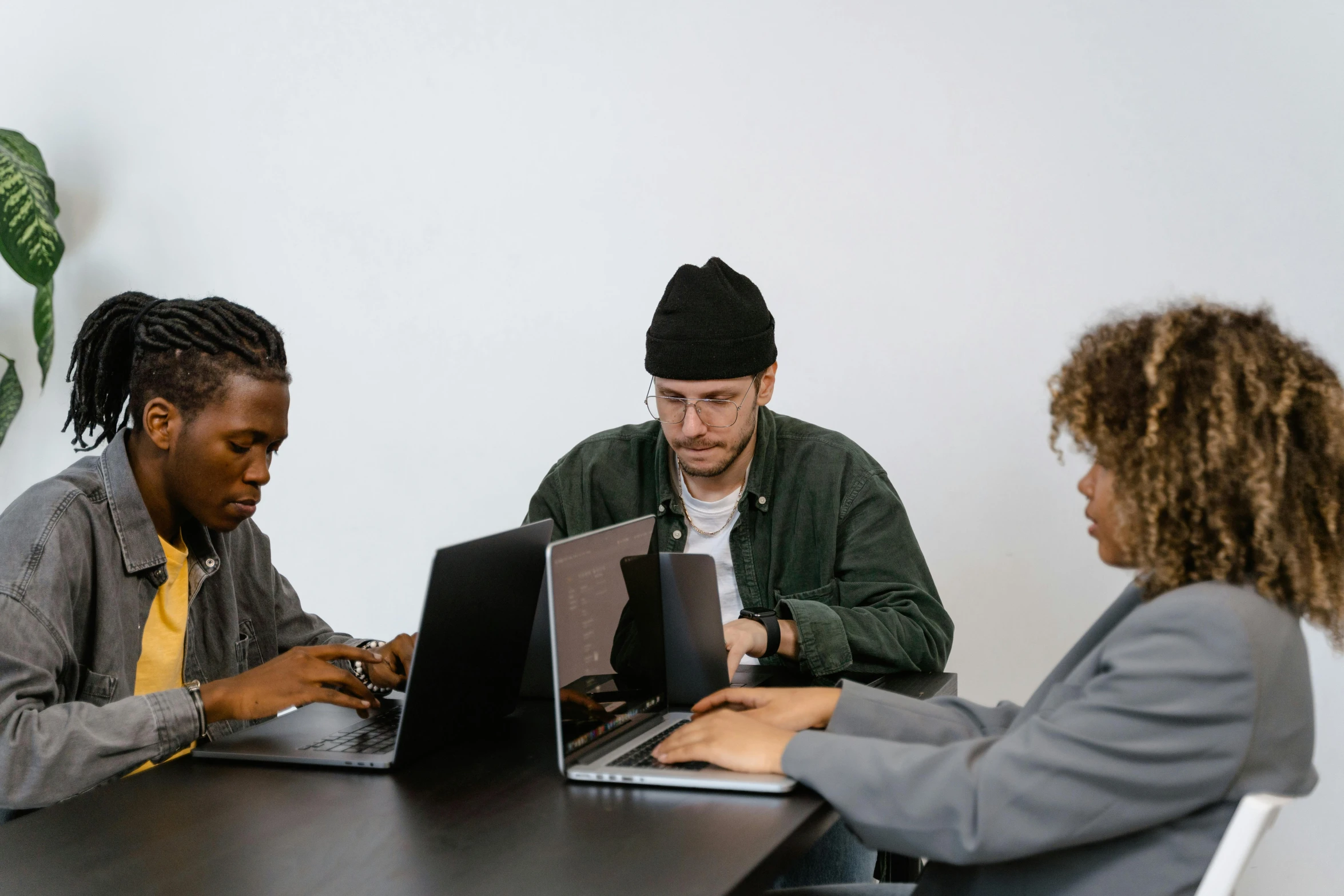 a group of people sitting around a table with laptops, by Carey Morris, trending on pexels, arbeitsrat für kunst, on a gray background, programmer, rule of three, panel of black