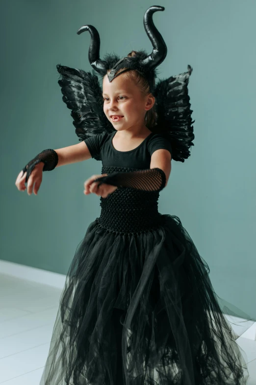 a little girl dressed up as a maleficent, pexels contest winner, dressed as a ballerina, winged, black textured, a handsome