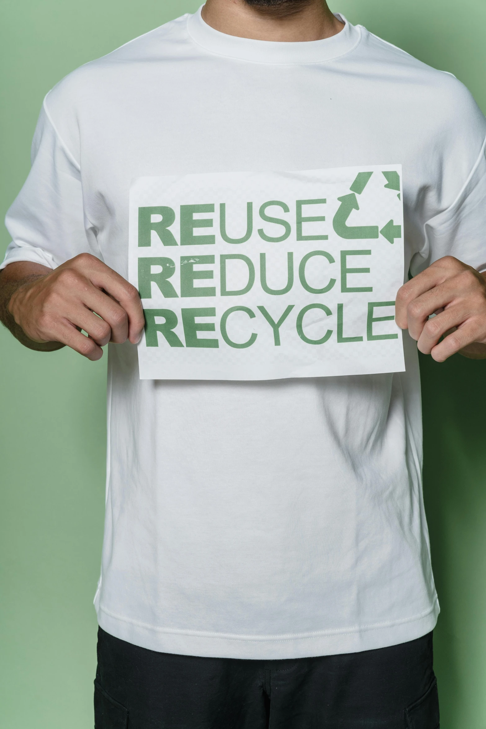 a man holding a sign that says reuse reduce recycle, reddit, portrait image, torn shirt, promo image, close - up photograph