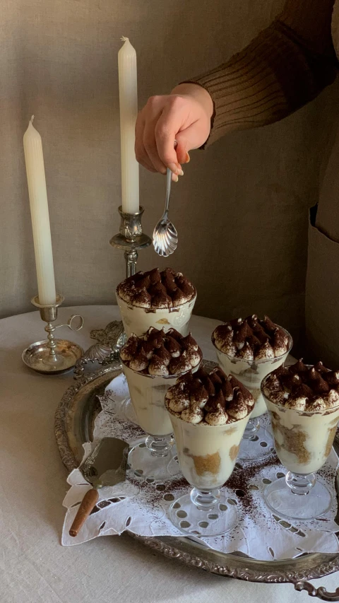 a silver tray topped with desserts on top of a table, profile image, milkshake, holding a candle holder, instagram photo