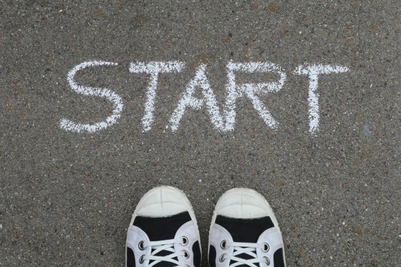 a person standing in front of a sign that says start, by Adam Marczyński, trending on pixabay, wearing white sneakers, chalk, wide high angle view, avatar image