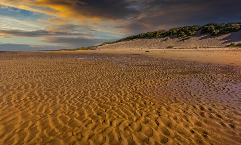 a sandy beach with footprints in the sand, by Jan Tengnagel, unsplash contest winner, baroque, evening light, ochre, landscape vista, whealan