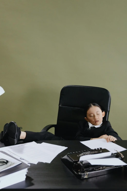 a little boy that is sitting at a desk, an album cover, inspired by Fei Danxu, pexels contest winner, office furniture, asleep, woman in black business suit, bella poarch