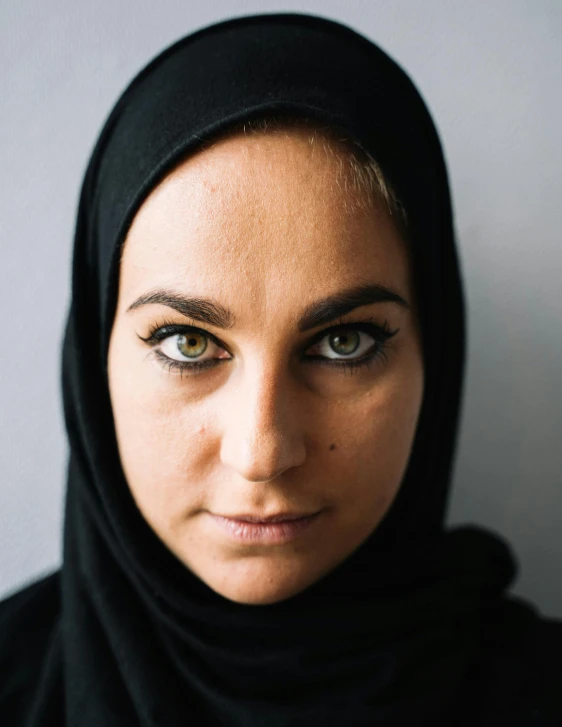 a close up of a person wearing a headscarf, an album cover, black intense eyes, lgbtq, blank stare”, trending photo