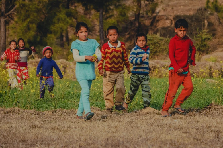 a group of children running in a field, pexels contest winner, nepal, avatar image, casually dressed, holding close