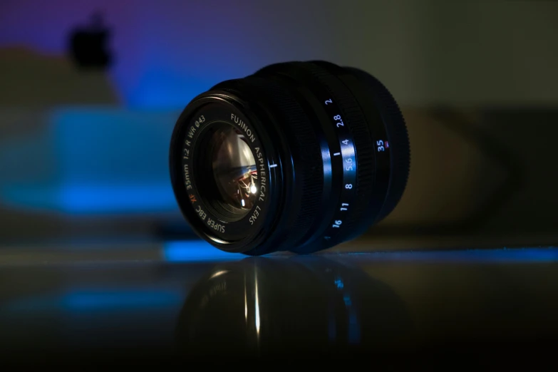 a camera lens sitting on top of a table, by Mathias Kollros, pexels contest winner, soft lighting and focus, shot on sony a 7, wide angle lens glow in the dark, medium format. soft light