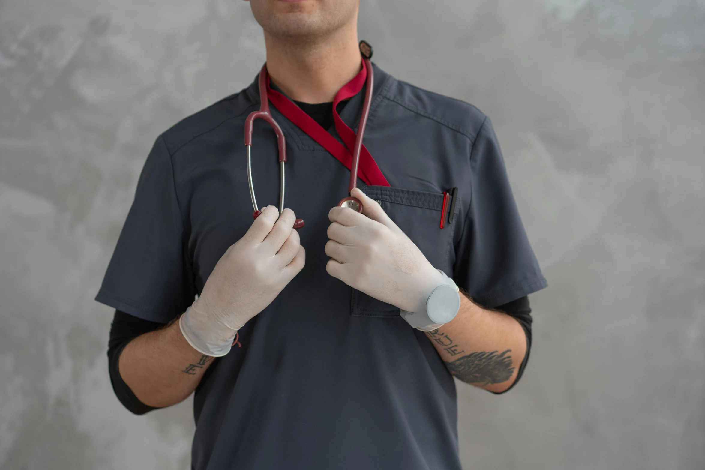 a man with a stethoscope around his neck, by Meredith Dillman, pexels contest winner, red gloves, grey, avant designer uniform, holding knife