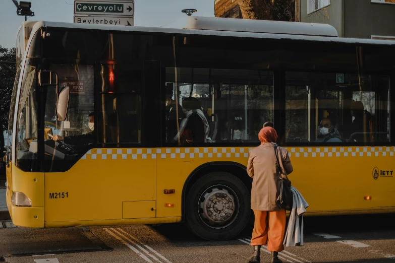 a person standing in front of a yellow bus, pexels contest winner, hurufiyya, thumbnail, istanbul, brown, high quality product image”