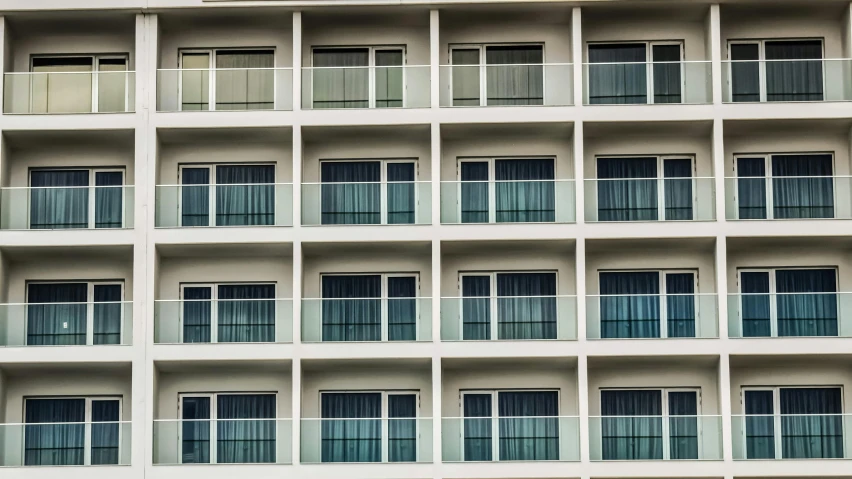 a large white building with many windows and balconies, by Carey Morris, unsplash, hotel room, square lines, vacation photo, modeled