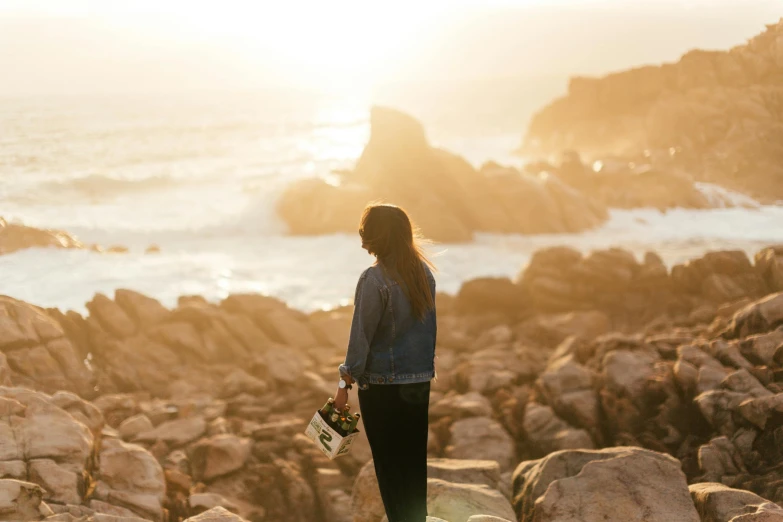 a woman standing on top of a rocky beach, pexels contest winner, golden hour in pismo california, knight of cups, profile image, al fresco