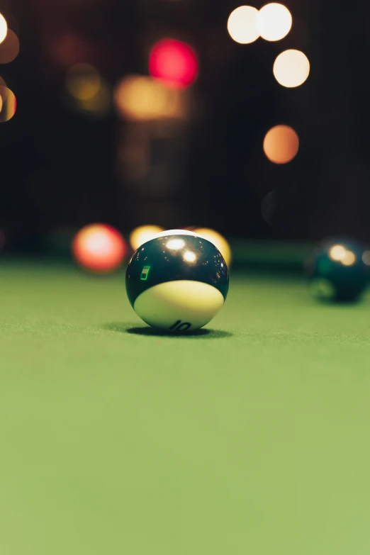 a pool ball sitting on top of a green table, at night