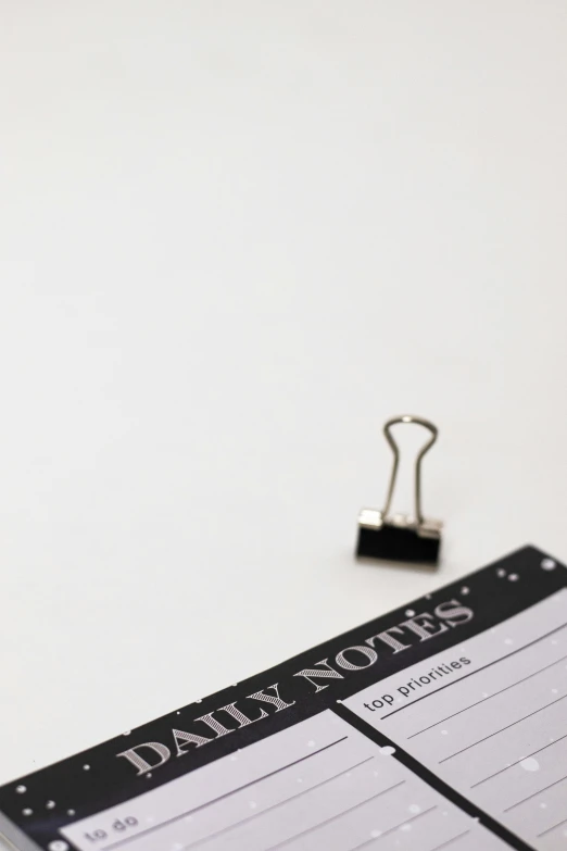 a notepad sitting on top of a desk next to a binder, by Andries Stock, white sky, tiny details, thumbnail, high quality image”