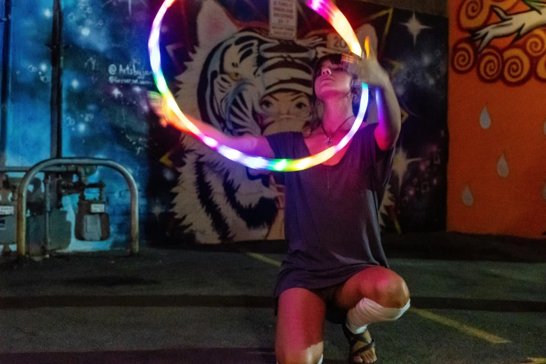 a woman is playing with a hula hoop, pexels contest winner, kinetic art, neon streetlights, holding a lantern, promotional photo, ringflash lighting