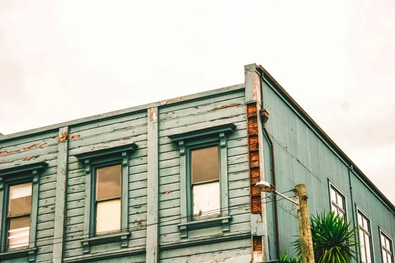 a green building with a red fire hydrant in front of it, inspired by Elsa Bleda, unsplash, wood print, picton blue, bay window, ignant