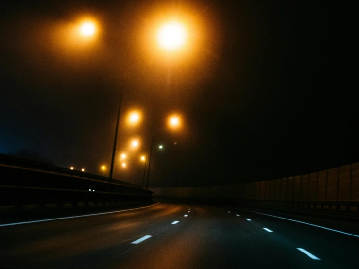 a car driving down a highway at night, an album cover, inspired by Elsa Bleda, unsplash, realism, midnight mist streetlights, the scary empty liminal spaces, headlights turned on, volumetric light fog