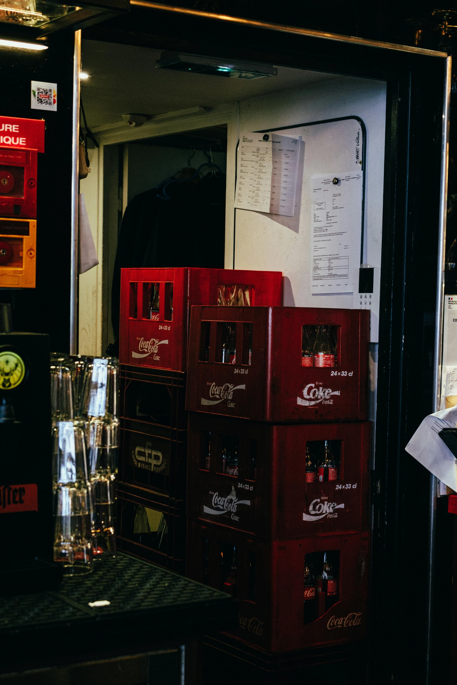 a man standing in front of a vending machine, black and red colour palette, beer glasses, shipping containers, concert