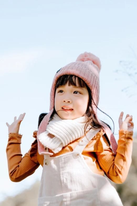 a little girl wearing a pink hat and scarf, inspired by Ma Yuanyu, pexels contest winner, sunny day with clear sky, excited, young asian girl, brown