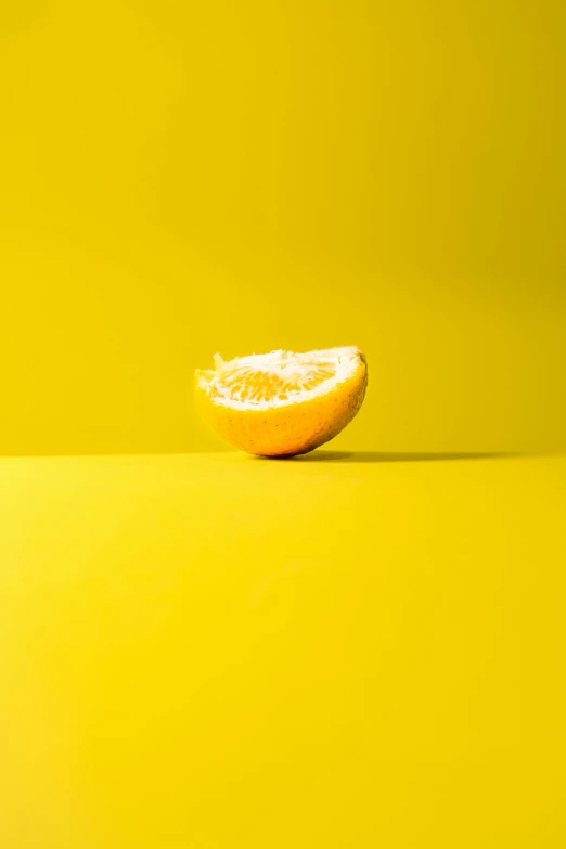 a half of an orange on a yellow background, a picture, by Leo Leuppi, pexels contest winner, postminimalism, 🍸🍋, clemens ascher, fruit, 🐿🍸🍋