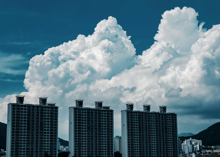 a group of tall buildings sitting next to each other, inspired by Thomas Struth, pexels contest winner, surrealism, giant cumulonimbus cloud, residential area, white cloud, video