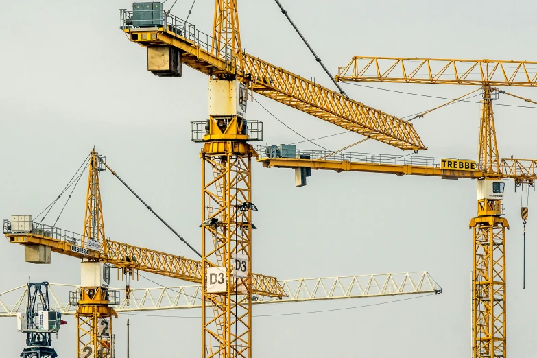 a group of yellow cranes sitting on top of a building, pexels contest winner, constructivism, mega-detailed, high quality product image”, large scale, 2022 photograph