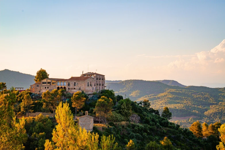 a large building sitting on top of a lush green hillside, inspired by Serafino De Tivoli, pexels contest winner, pink golden hour, cézanne style, conde nast traveler photo, preserved historical