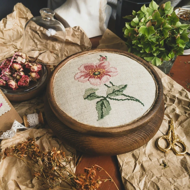 a table topped with a wooden bowl filled with flowers, a cross stitch, inspired by Károly Markó the Elder, trending on pexels, arts and crafts movement, natural point rose', unfinished, circle, herbarium page