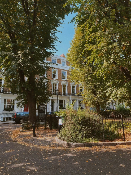 a large white house sitting on the side of a road, by Elsie Henderson, unsplash, art nouveau, park on a bright sunny day, in london, panoramic view, ignant