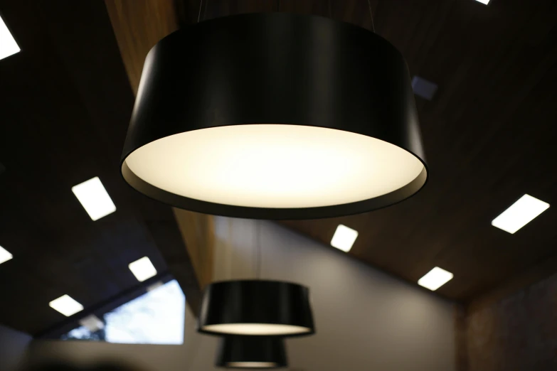 a couple of lamps hanging from the ceiling, by Thomas Häfner, uplight, warmly lit, light and dark, rounded ceiling