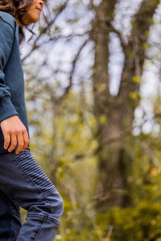 a man riding a skateboard down the side of a road, a picture, by Jan Tengnagel, trending on unsplash, renaissance, wearing a hoodie and sweatpants, standing in a forest, heavy gesture style closeup, wearing jeans