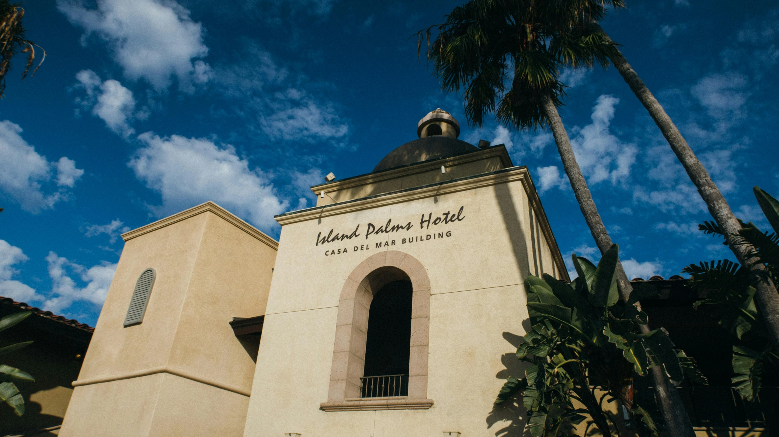 a church with palm trees in front of it, an album cover, inspired by Dalí, unsplash, david palladini, restaurant, hearst castle, inside the building