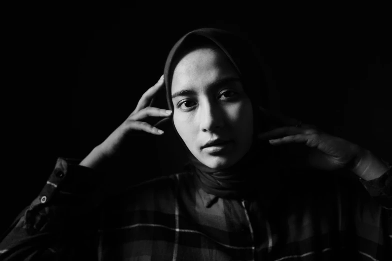 a black and white photo of a woman in a hoodie, a black and white photo, inspired by irakli nadar, hurufiyya, medium format, malaysian, portrait 8 k, low iso