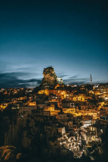 a city lit up at night with a mountain in the background, pexels contest winner, renaissance, turkey, stacked image, full frame image, cliffside town