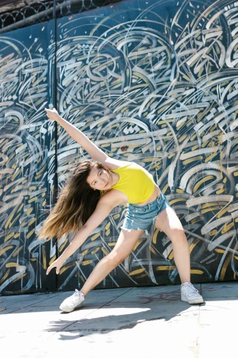 a woman is dancing in front of a graffiti wall, wearing yellow croptop, sydney sweeney, canvas, profile image