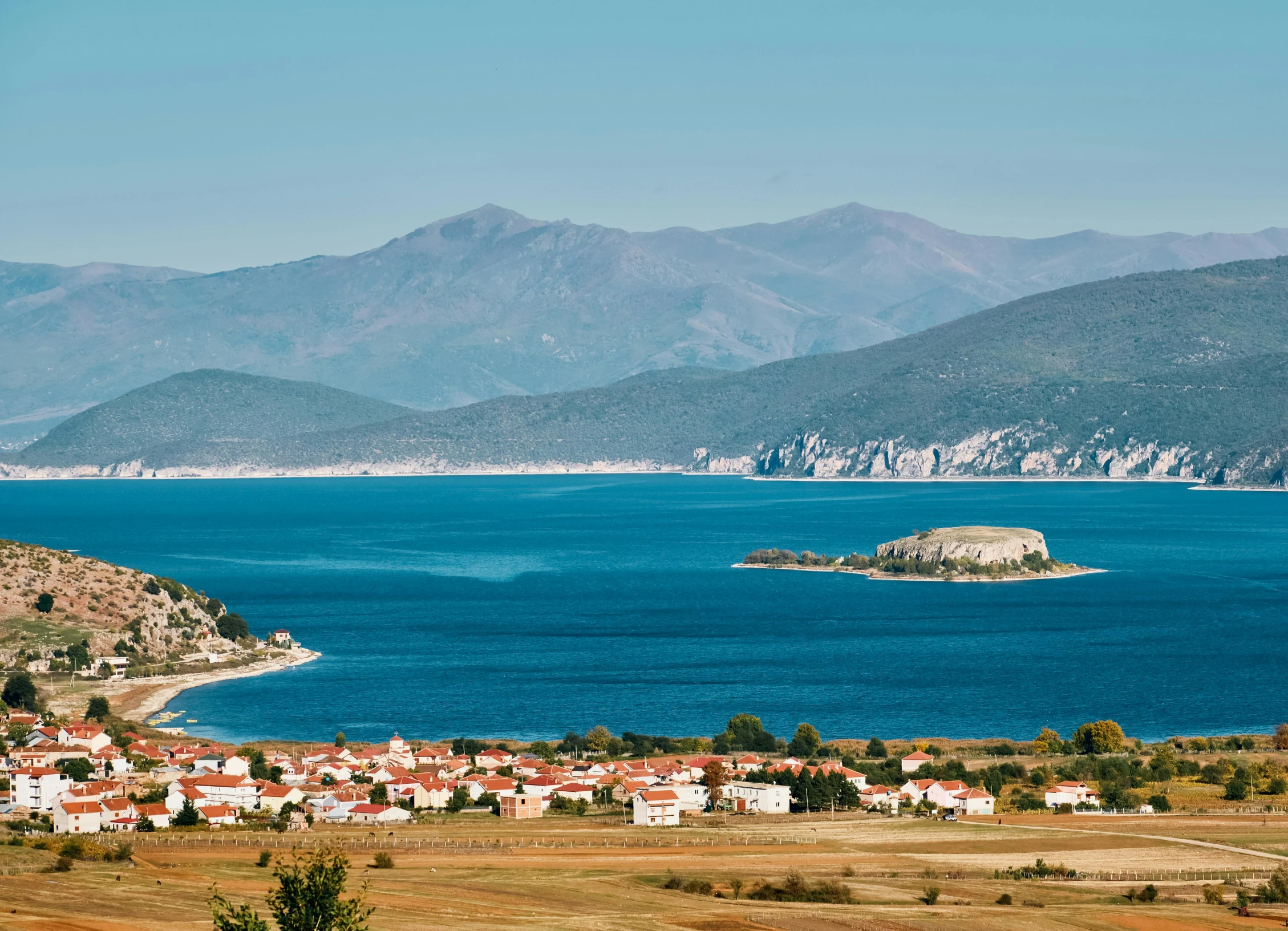 a large body of water surrounded by mountains, by Muggur, pexels contest winner, renaissance, croatian coastline, russian villages at background, thumbnail, high quality product image”