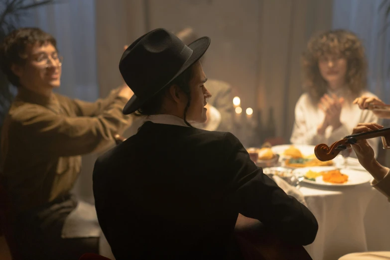 a group of people sitting around a dinner table, he is wearing a hat, cinematic lighting + masterpiece, a pilgrim, shot from the side